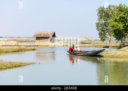 Satkhira, Bangladesh - 29 janvier 2017 : la mère et son jeune enfant pêchent sur un étang avec un bateau traditionnel de campagne en bois Banque D'Images