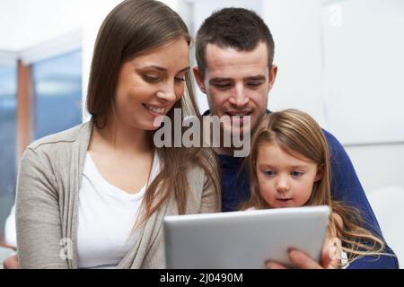 La technologie nous aide à communiquer avec la famille. Une famille utilisant leur nouvelle tablette numérique. Banque D'Images