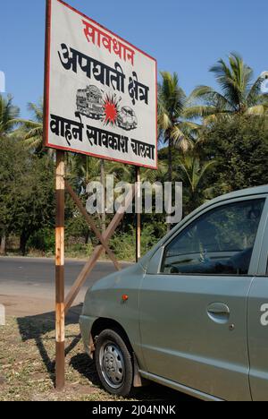 Sangli Maharashtra Inde décembre 09 2006 Un panneau d'accident de la circulation au milieu d'une route très fréquentée, les voitures passant sur l'un ou l'autre côté du tableau montrant la prudence vont lent Banque D'Images