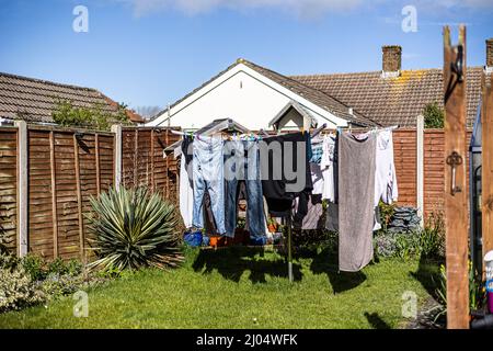 Jardin arrière d'un bungalow avec des vêtements suspendus sur la ligne de lavage Banque D'Images