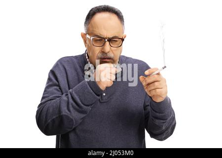 Homme mature tenant une cigarette et toussant isolé sur fond blanc Banque D'Images