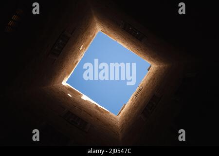 Fenêtre lumineuse carrée dans l'intérieur de la tour sombre, photo abstraite d'arrière-plan architectural sombre Banque D'Images