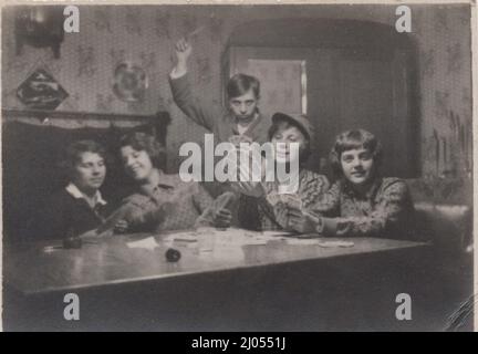 photo vintage originale au sujet d'une famille ( jeune garçon et une fille et des mamans ) fête de carte dont sont assis autour d'une carte à jouer (carte à jouer adaptée à l'allemand) des années 1930 Banque D'Images