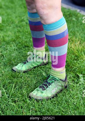 Des chaussettes colorées et des chaussures de course à pied d'un coureur de chute sur Ilkley Moor dans le West Yorkshire avec les coureurs de North Leeds Fell. Banque D'Images
