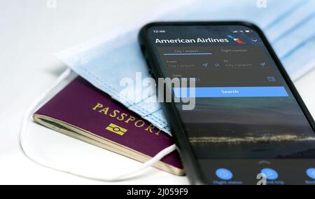 New York, Etats-Unis, mars 2022 : téléphone avec l'application mobile American Airlines sur l'écran, au-dessus d'un masque de protection et d'un passeport. Sécurité de voyage et réf Banque D'Images