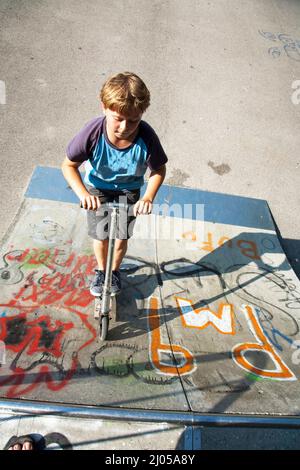 garçon a le plaisir de faire du picage dans le parc de skate Banque D'Images