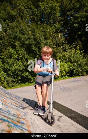 garçon a le plaisir de faire du picage dans le parc de skate Banque D'Images