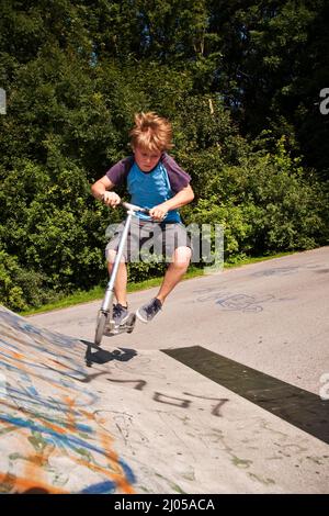 garçon a le plaisir de faire du picage dans le parc de skate Banque D'Images