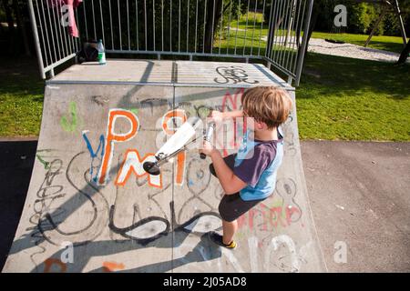 garçon a le plaisir de faire du picage dans le parc de skate Banque D'Images