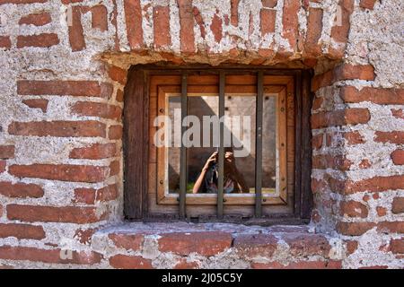 Vieille fenêtre avec fer à repasser et mur de briques rouges autour à Cordoue Argentine. Horizontale Banque D'Images