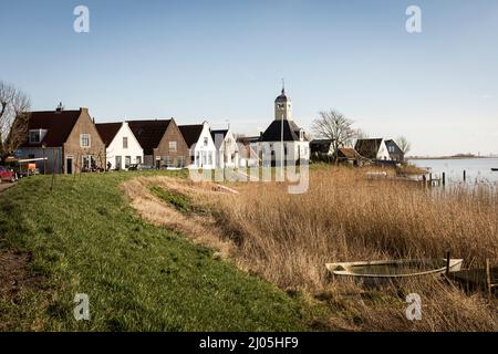 Une vue sur la digue vers la chapelle du village de Durgerdam lors d'une journée ensoleillée de printemps, à Amsterdam, aux pays-Bas. Banque D'Images