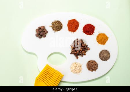 palette de peintre et pinceau avec des épices séchées colorées comme couleurs Banque D'Images