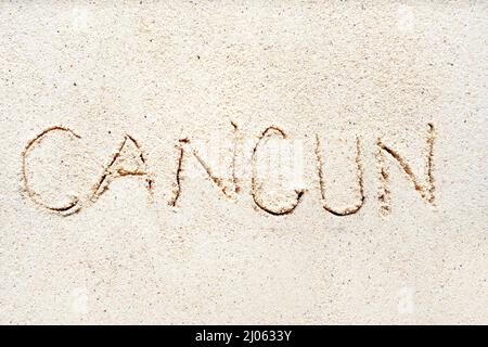 Écriture des mots « Cancun » sur sable de la plage Banque D'Images