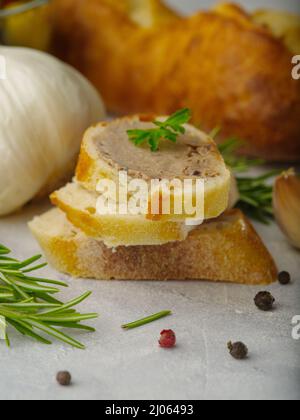 Gros plan. Foie gras sur morceaux de baguette, légumes verts, ail, boules de poivre noir sur fond blanc. Restaurant cuisine plat, cuisine gastronomique, restaurant, h Banque D'Images