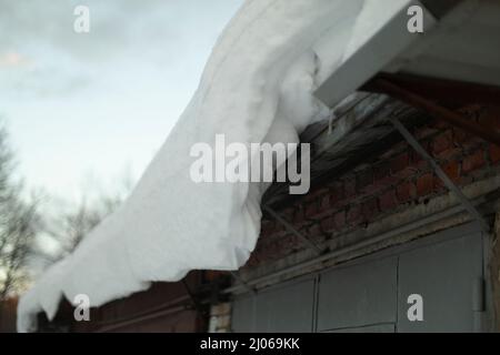 Neige sur le toit. Pente du toit en hiver. Détails de la météo de la neige. Couche épaisse de glace. Banque D'Images