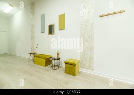 Salle de réception d'un salon de beauté avec porte-manteaux et sièges capitonnés de velours vert pistache Banque D'Images