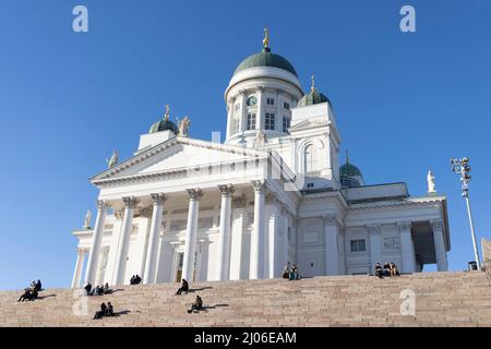 Helsinki, Finlande. 16th mars 2022. Les gens se prélassent au soleil à l'escalier de la cathédrale d'Helsinki, en Finlande, le 16 mars 2022. Credit: Matti Matikainen/Xinhua/Alamy Live News Banque D'Images