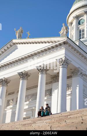 Helsinki, Finlande. 16th mars 2022. Les gens se prélassent au soleil à l'escalier de la cathédrale d'Helsinki, en Finlande, le 16 mars 2022. Credit: Matti Matikainen/Xinhua/Alamy Live News Banque D'Images