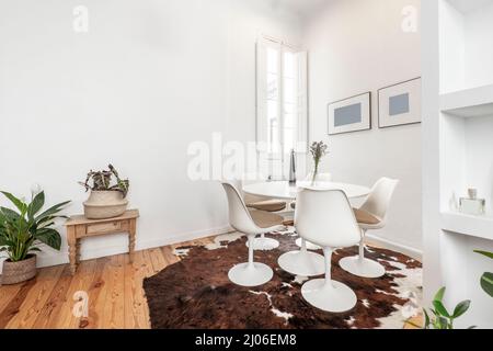 Coin avec une table ronde avec chaises assorties sur un cowhide sur des planchers de pin Banque D'Images