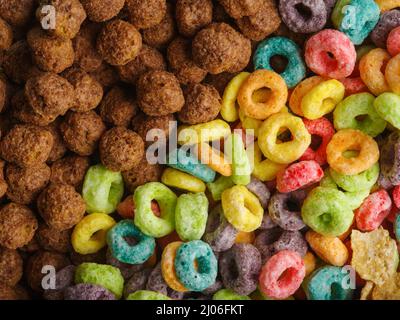 Petits déjeuners rapides aux céréales entières sucrées - boules de chocolat et anneaux de fruits. Express alimentaire, alimentation saine, vitamines, glucides, supermarché, bannière. Fermer- Banque D'Images