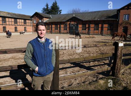 Panker, Allemagne. 11th mars 2022. Achaz von Wintzingerode, administrateur de la Fondation Hessian House à Gut Panker, se dresse devant une écurie de chevaux sur le domaine. Afin de maintenir les grands domaines du Schleswig-Holstein, des entreprises fortes sont nécessaires. Là où l'agriculture et la foresterie ne suffisent pas, les seigneurs et les dames du manoir comptent sur les marchés et les événements de Noël. (À dpa-Korr 'vacances sur la ferme vraiment grande: Le tourisme de domaine dans le nord') crédit: Christian Charisius/dpa/Alay Live News Banque D'Images