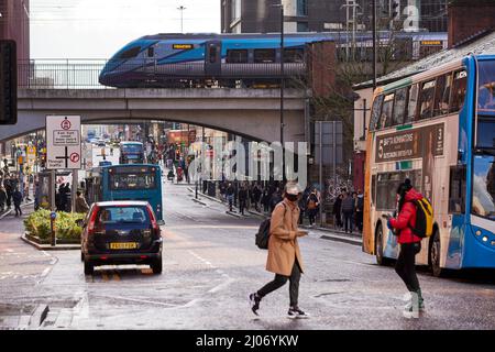 Scène de rue Oxford Road Manchester, TPE train sur une voie surélevée à travers le centre-ville Banque D'Images