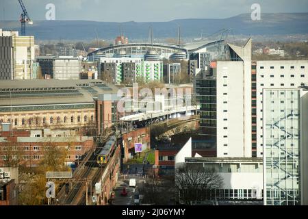 Trains à Manchester Piccadilly plates-formes 13 14, avec Manchester City FC Etihad stade sur la ligne d'horizon Banque D'Images