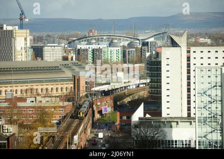 Trains à Manchester Piccadilly plates-formes 13 14, avec Manchester City FC Etihad stade sur la ligne d'horizon Banque D'Images