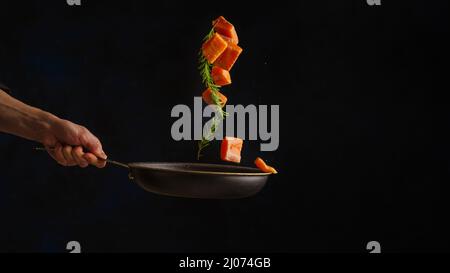 Cuisine de mer, cuisine professionnelle prépare des morceaux de poisson rouge, saumon, truite avec des légumes.cuisine de fruits de mer, nourriture végétarienne saine et de la nourriture sur un sombre Banque D'Images