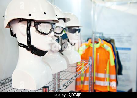 Casques et lunettes de protection dans un magasin de vêtements de travail Banque D'Images