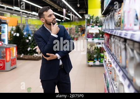 l'homme choisit l'huile moteur pour sa voiture Banque D'Images