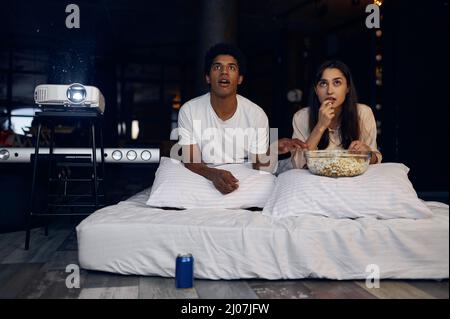 Couple drôle regardant un film d'horreur dans la chambre Banque D'Images