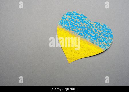 Aucun enfant de guerre faisant symbole coeur Ukraine drapeau peint jaune bleu. Symbole national ukraine peint enfant dessin coeur isolé sur fond gris Banque D'Images