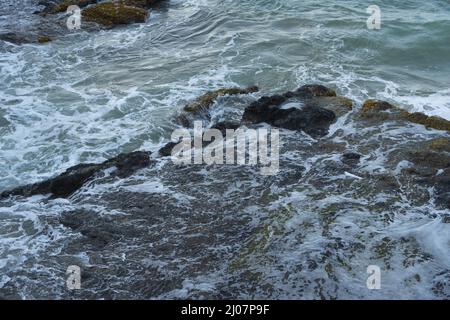 Les vagues de la mer de l'impact de la ligne des cils rock sur la plage Banque D'Images