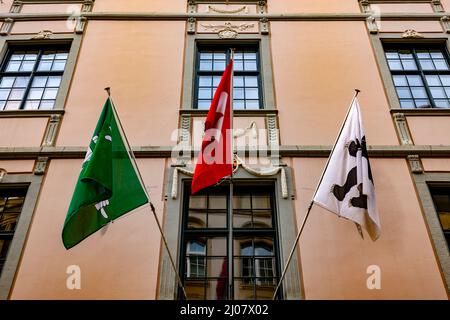 Drapeaux suisses et de canton suspendus sur le bâtiment de façade lors d'une journée de vent à St Gall, Suisse. *** Légende locale *** maison,drapeau,suisse,drapeaux,canton,natio Banque D'Images