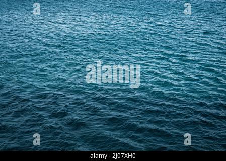 Mer calme et bleu profond avec des ondulations à la surface de l'eau. Fond et texture bleu foncé Banque D'Images