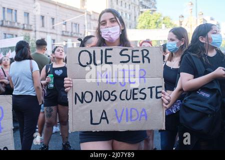 Buenos Aires, Argentine; 8 mars 2022: Grève féministe internationale, une jeune femme tient un carton avec le texte que le fait d'être une femme ne coûte pas Banque D'Images