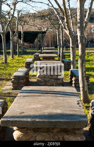 Aire de pique-nique extérieure, tables en pierre dans une zone d'arbres, Abadia, Caceres, Estrémadure, Espagne Banque D'Images