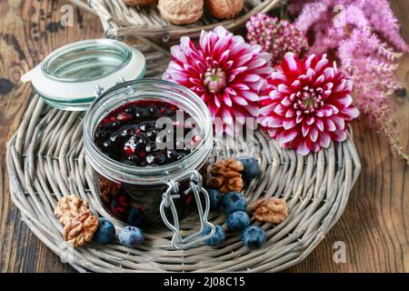 Pot de confiture de myrtilles et de fleurs de dahlia. Une alimentation saine Banque D'Images