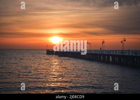 Paysage matinal coloré en bord de mer. Jetée en bois sur la mer au lever du soleil. Banque D'Images