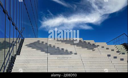 En regardant sur des marches de béton vides et un ciel bleu clair avec des nuages blancs moelleux Banque D'Images