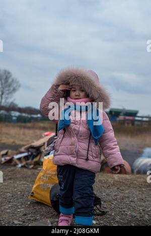 Photo verticale d'une fille ukrainienne debout avec des bagages dans un camp de Medyka, en Pologne Banque D'Images