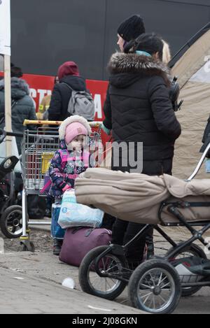 Tir vertical d'une fille ukrainienne debout avec d'autres réfugiés dans un camp de Medyka, en Pologne Banque D'Images
