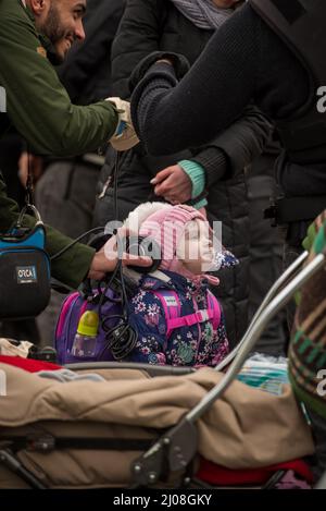 Tir vertical d'une fille ukrainienne debout avec d'autres réfugiés dans un camp de Medyka, en Pologne Banque D'Images