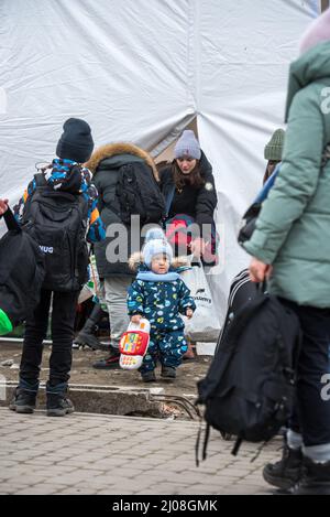 Tir vertical d'un garçon ukrainien debout avec d'autres réfugiés dans un camp de Medyka, en Pologne Banque D'Images