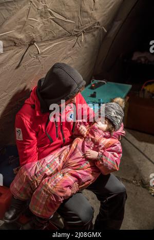 Plan vertical d'un réfugié ukrainien avec un enfant endormi dans le camp de Medyka, en Pologne Banque D'Images