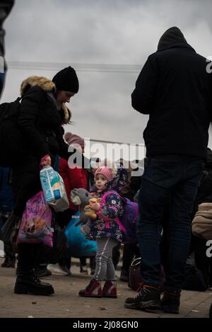 Tir vertical d'une fille ukrainienne debout avec d'autres réfugiés dans un camp de Medyka, en Pologne Banque D'Images