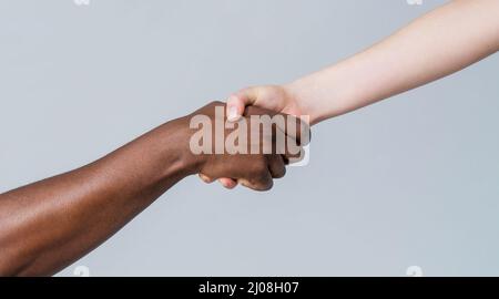 Mains humaines noires et blanches. Mains africaines et caucasiennes. Donner un coup de main à un autre. Femme et femme africaine main. Aide main, sauvetage Banque D'Images