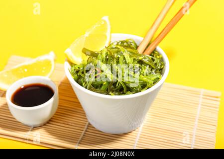 Bol avec salade d'algues saines sur fond jaune Banque D'Images