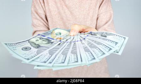 Une femme tenant l'argent a délatisé ostensiblement le montrant. Le concept obtenant une grande quantité d'argent Banque D'Images